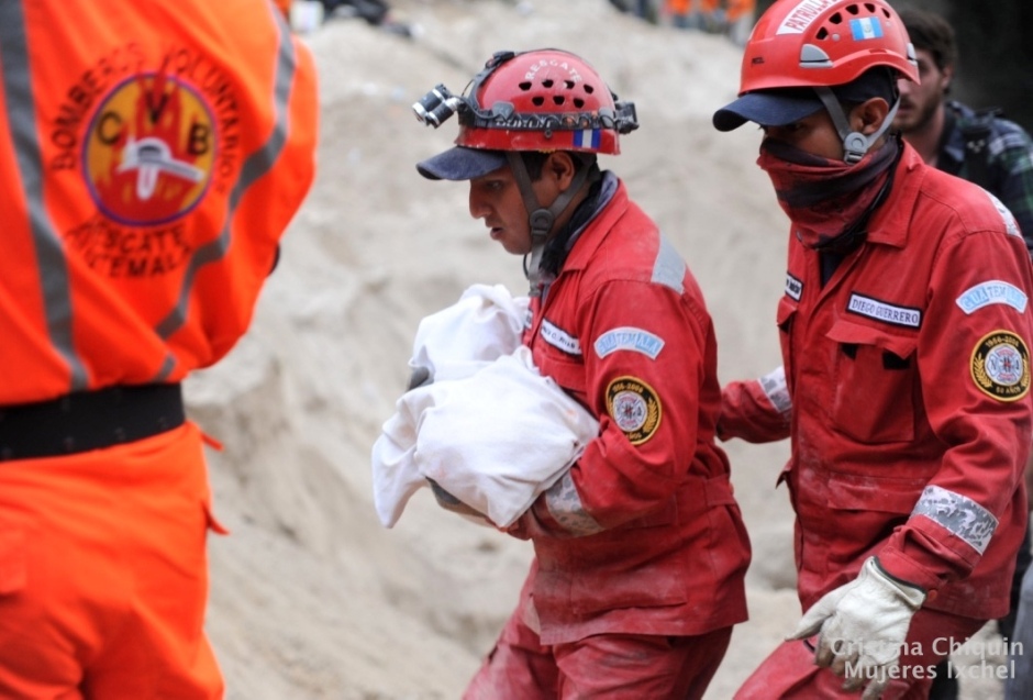 Dos bomberos llevan el cuerpo de un bebe víctima del deslave en la comunidad de Cambray II en Santa Catarina Pinula en Guatemala. El desastre ocurrió el 1 de Octubre del 2015, muchas de las vícitimas eran niñas y niños.